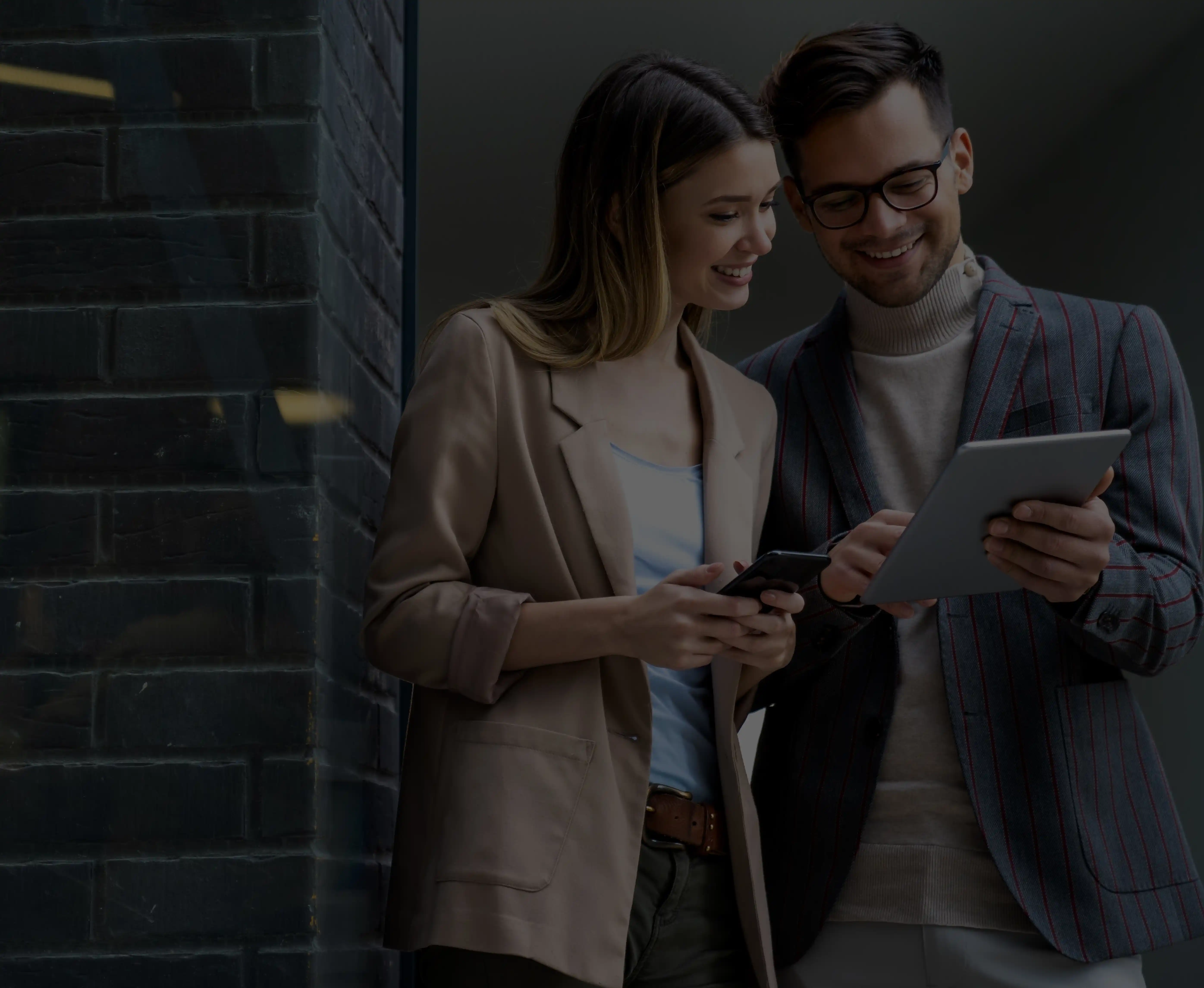 Positive Collaboration: In this heartwarming image, two individuals joyfully hold up their phones, wearing bright smiles that radiate their happiness to work with our esteemed global web technology agency.